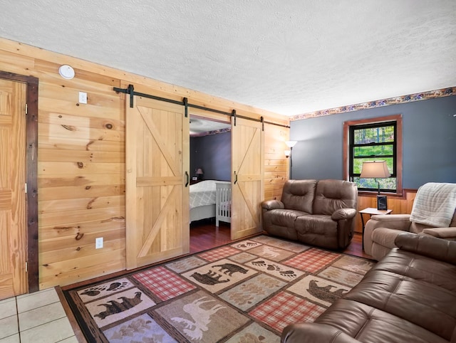 543 Drybrook Rd, Waverly, NY 14892 - living room with a barn door, wooden walls, and a textured ceiling