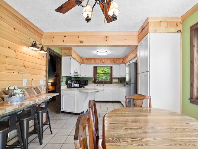 543 Drybrook Rd, Waverly, NY 14892 - kitchen featuring freestanding refrigerator, light countertops, light tile patterned floors, white cabinetry, and a chandelier
