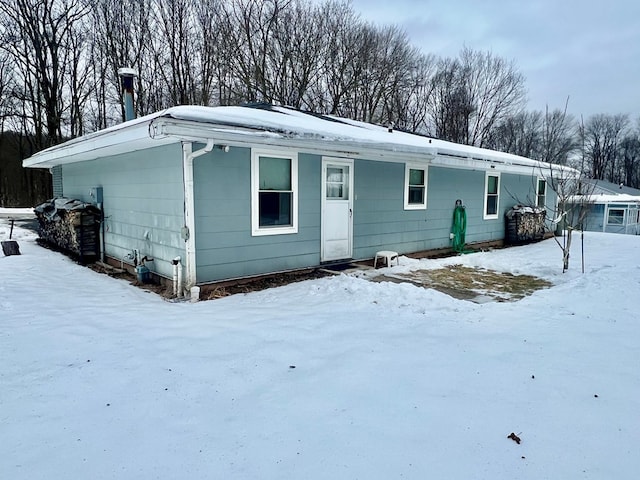 view of snow covered back of property