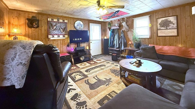 living area with a ceiling fan and wooden walls