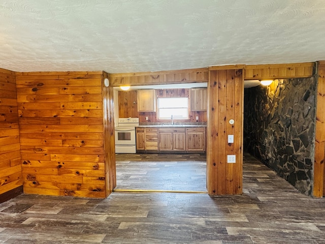 96 E St, Towanda, PA 18848 - kitchen featuring white electric range oven, a sink, dark wood-type flooring, wooden walls, and a textured ceiling