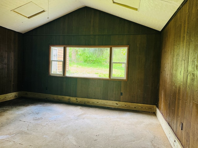 96 E St, Towanda, PA 18848 - empty room with attic access, vaulted ceiling, wooden walls, and carpet floors