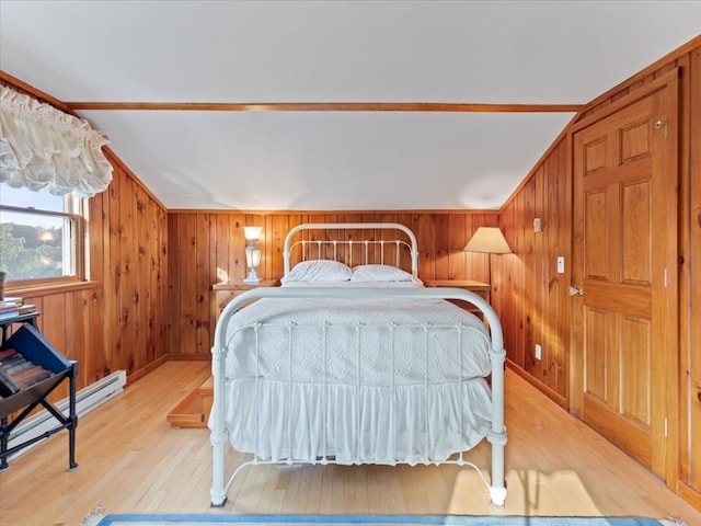 bedroom with light hardwood / wood-style flooring, vaulted ceiling, crown molding, and wood walls