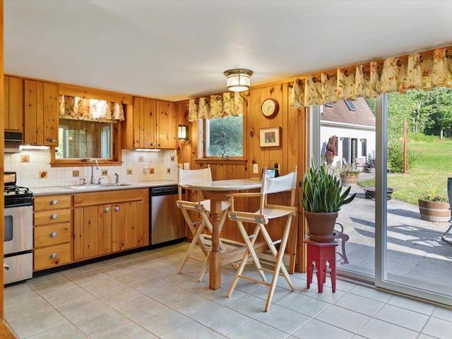 kitchen with sink, stainless steel appliances, tasteful backsplash, ventilation hood, and light tile patterned floors