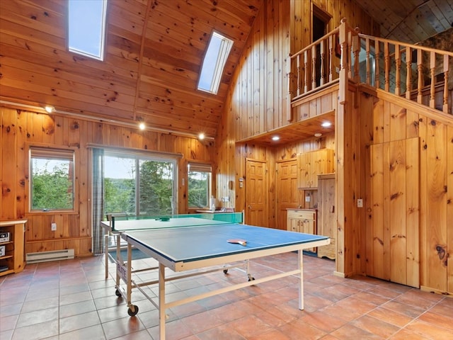 recreation room with a skylight, wood ceiling, baseboard heating, high vaulted ceiling, and light tile patterned flooring