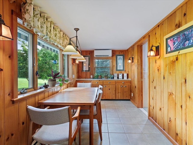 dining space featuring a wall mounted AC, wooden walls, and light tile patterned flooring