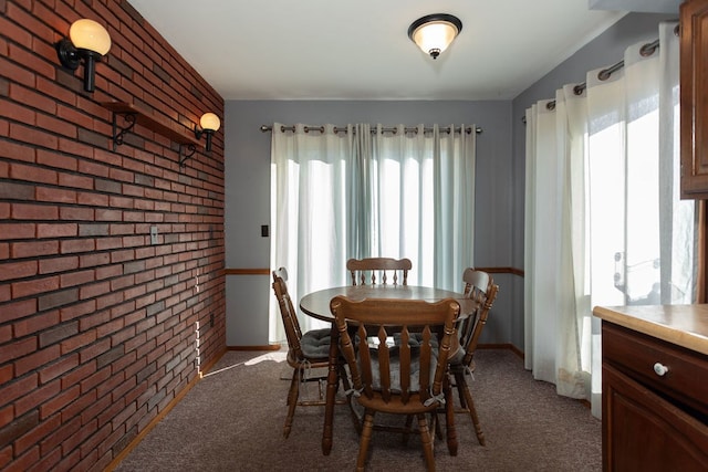 carpeted dining room with brick wall