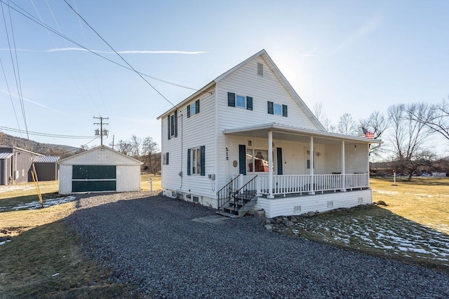 farmhouse featuring a garage, an outdoor structure, and a porch