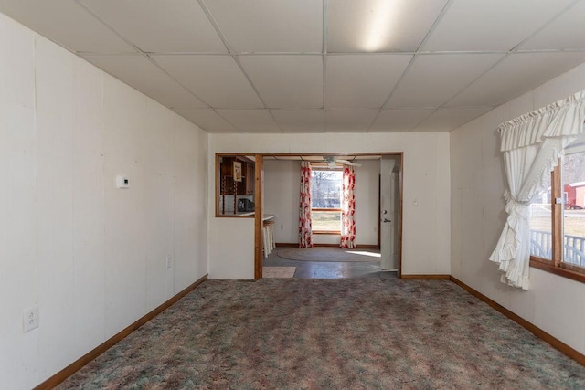 spare room with a paneled ceiling and carpet