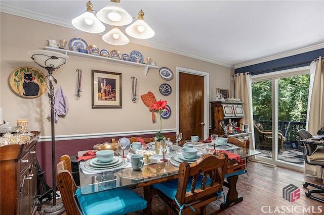 dining space featuring ornamental molding, dark hardwood / wood-style floors, and an inviting chandelier