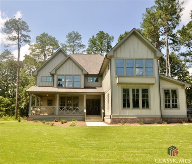 back of property featuring a yard and covered porch