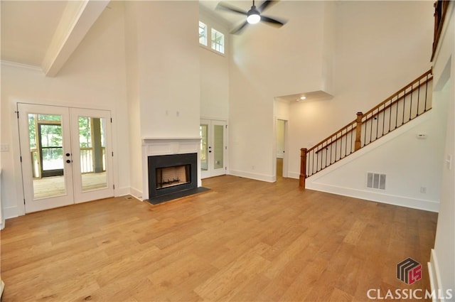 unfurnished living room with light hardwood / wood-style floors, french doors, and ceiling fan