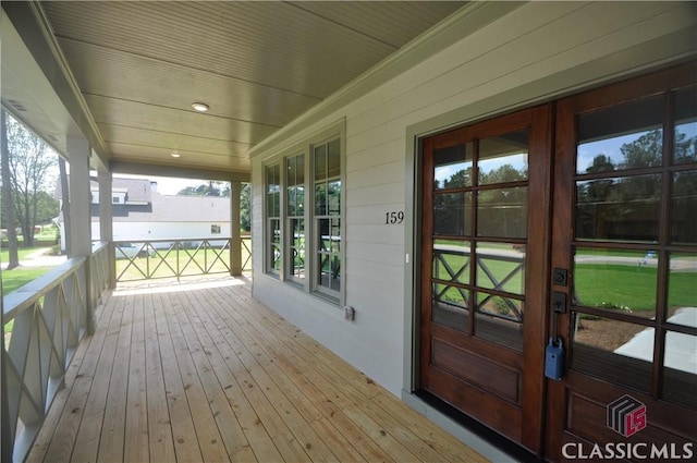 wooden terrace featuring french doors and a porch