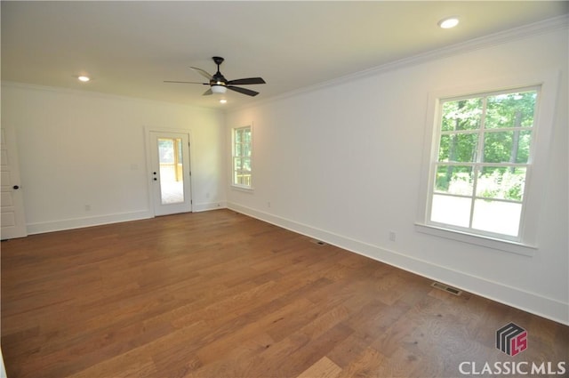 spare room with hardwood / wood-style floors, a wealth of natural light, and ornamental molding