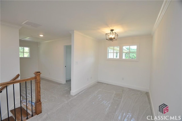 spare room featuring ornamental molding and an inviting chandelier