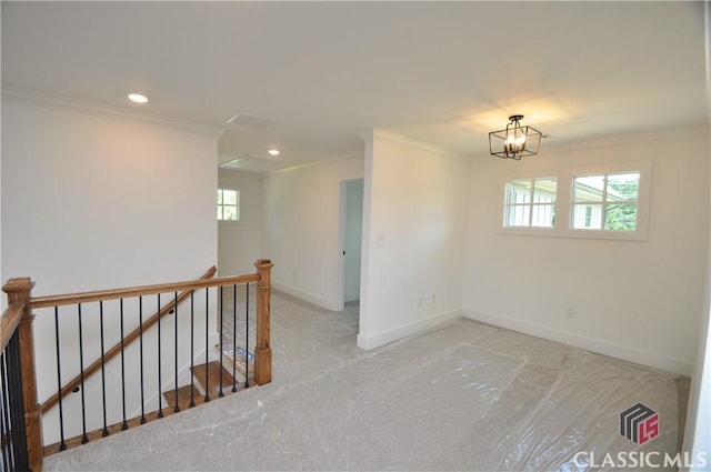 empty room featuring crown molding and a notable chandelier