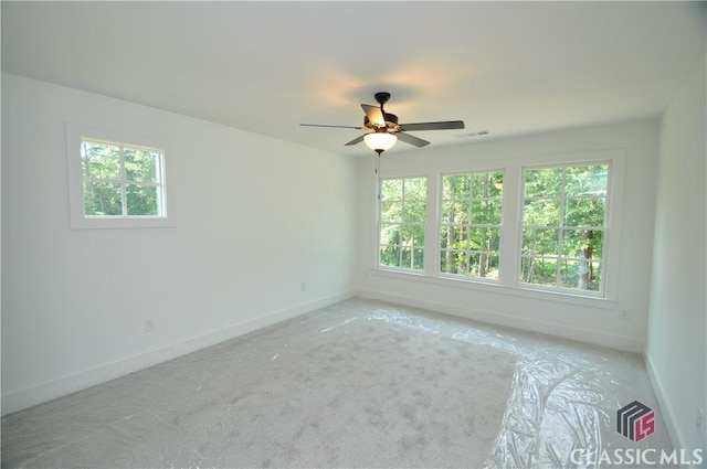 spare room with light carpet, a wealth of natural light, and ceiling fan