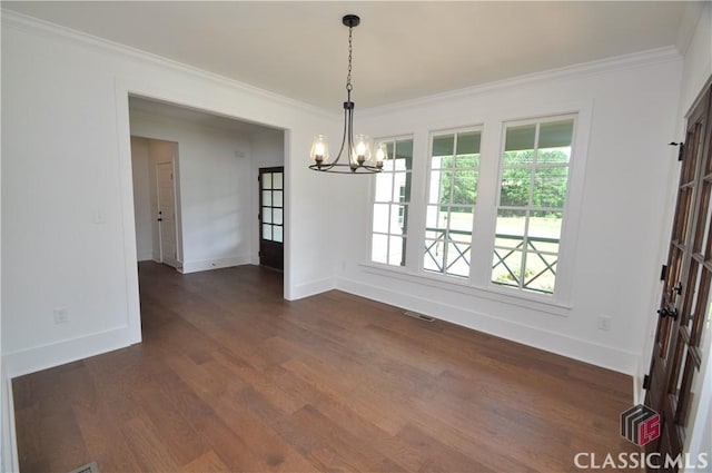 unfurnished dining area with an inviting chandelier, ornamental molding, and dark hardwood / wood-style flooring