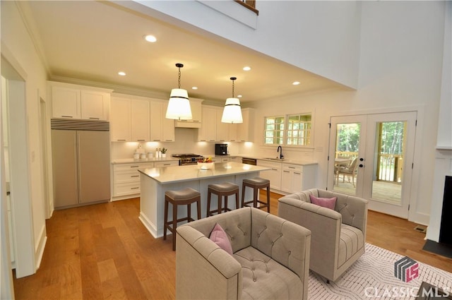 kitchen featuring a kitchen island, appliances with stainless steel finishes, sink, and white cabinets