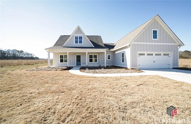 view of front of home with a garage, a front yard, and a porch