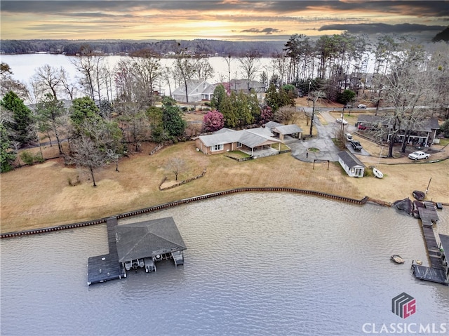 aerial view at dusk featuring a water view