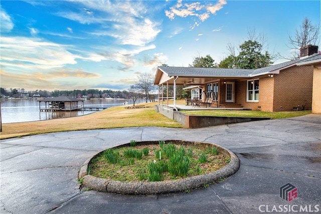 view of property's community featuring a yard, a boat dock, and a water view