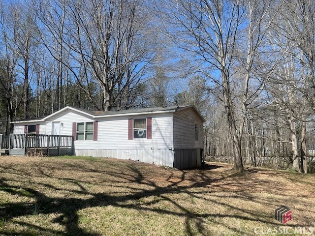 view of side of property with a lawn and a wooden deck