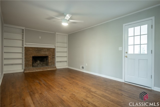 unfurnished living room featuring dark hardwood / wood-style flooring, ceiling fan, a brick fireplace, and crown molding