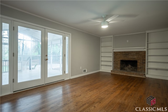 unfurnished living room with dark hardwood / wood-style flooring, ceiling fan, built in shelves, and plenty of natural light