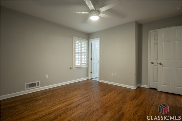 spare room with dark hardwood / wood-style flooring and ceiling fan