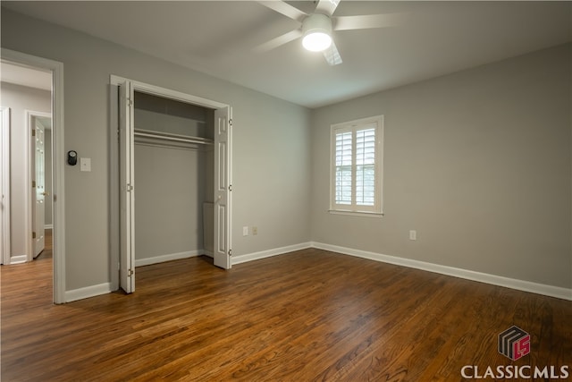 unfurnished bedroom with a closet, ceiling fan, and dark hardwood / wood-style flooring