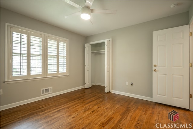 unfurnished bedroom with a closet, ceiling fan, and dark wood-type flooring