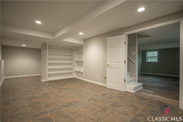 tiled empty room featuring built in shelves