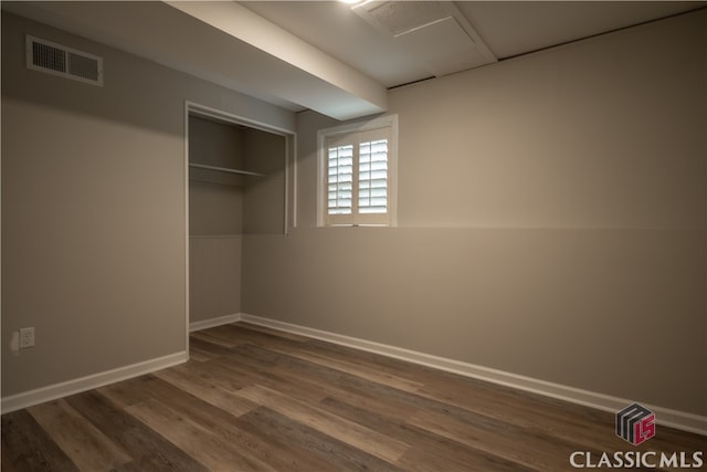 unfurnished bedroom featuring dark hardwood / wood-style flooring and a closet