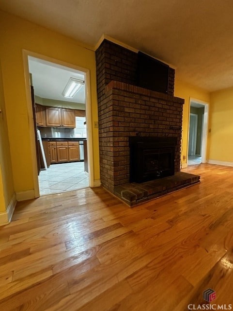 unfurnished living room featuring a fireplace and light hardwood / wood-style floors