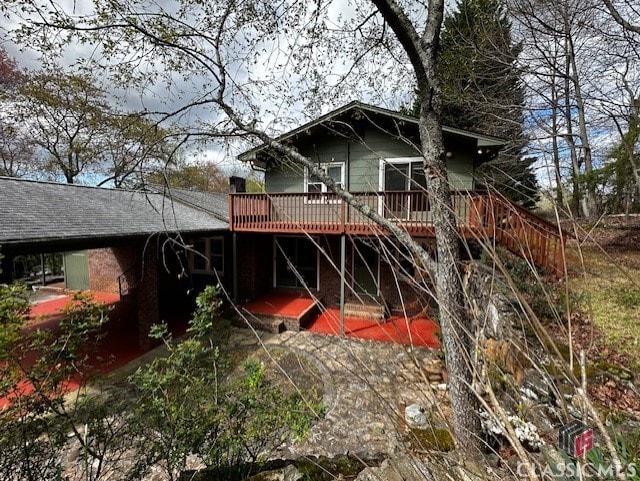 rear view of property with a wooden deck