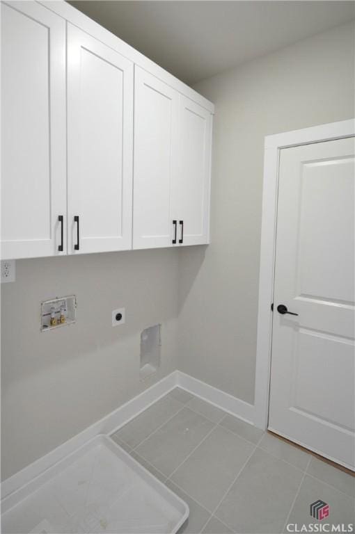 washroom with hookup for an electric dryer, cabinets, light tile patterned floors, and hookup for a washing machine