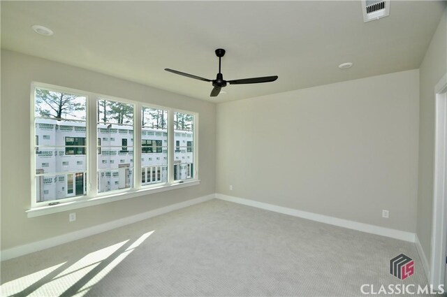 carpeted empty room featuring a wealth of natural light and ceiling fan