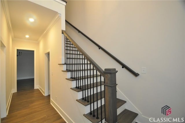 stairs featuring crown molding and hardwood / wood-style floors