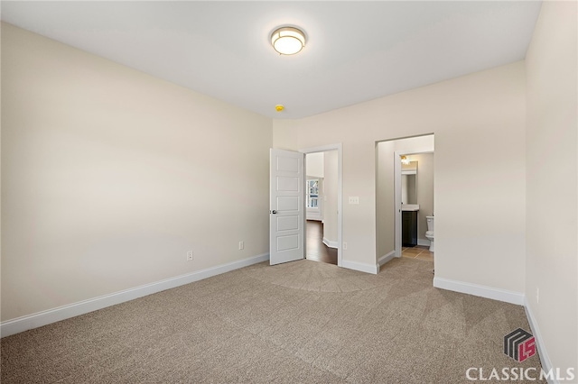 unfurnished bedroom with carpet flooring and ensuite bathroom