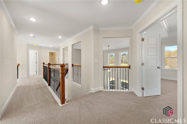 hallway featuring ornamental molding, light colored carpet, and a wealth of natural light