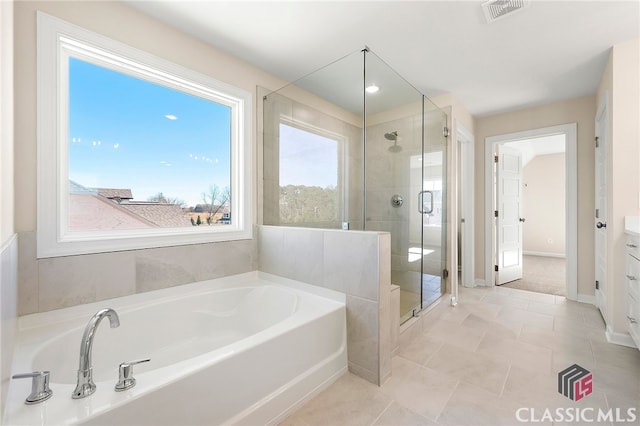 bathroom featuring plenty of natural light, vanity, tile floors, and separate shower and tub