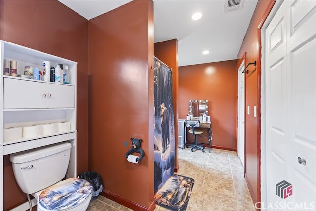 bathroom with tile flooring and toilet