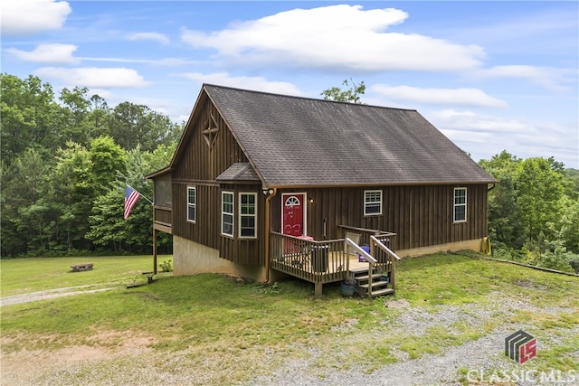 rear view of house with a lawn and a wooden deck