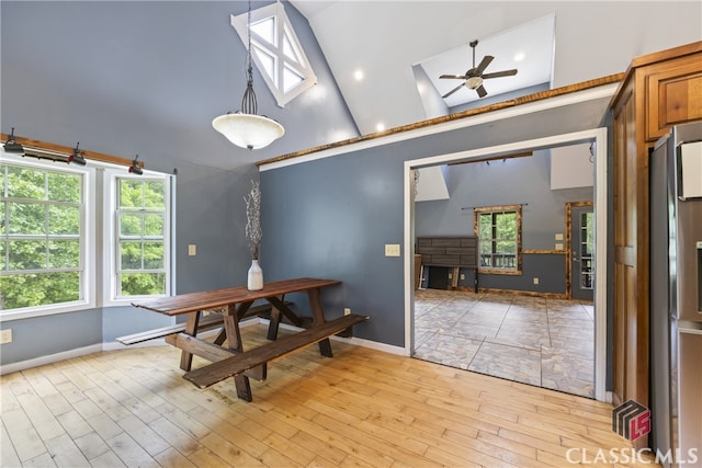 dining space with a wealth of natural light, ceiling fan, light wood-type flooring, and lofted ceiling