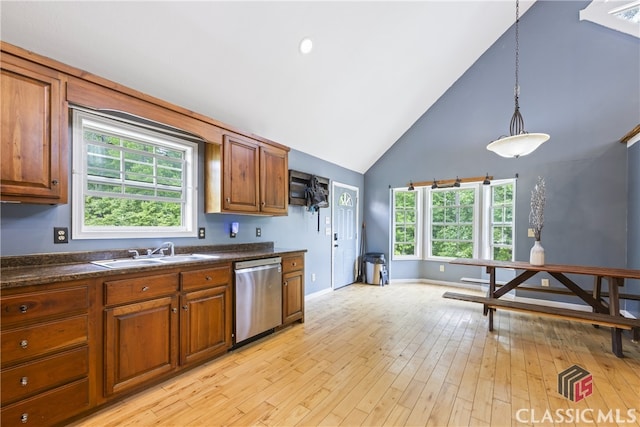 kitchen with stainless steel dishwasher, light wood-type flooring, pendant lighting, high vaulted ceiling, and sink