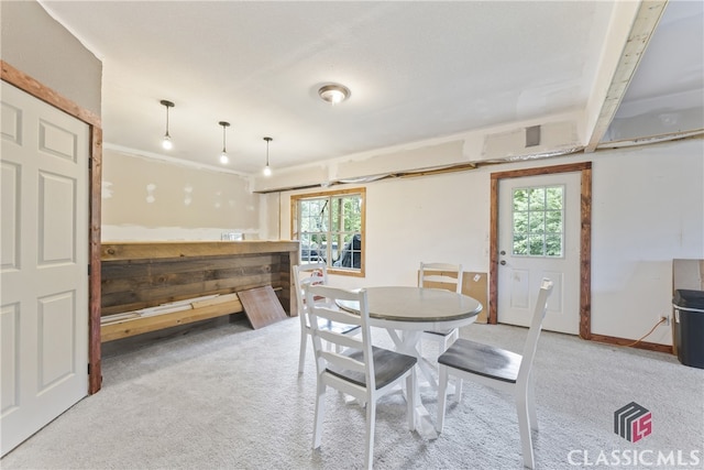 carpeted dining area featuring plenty of natural light and beam ceiling