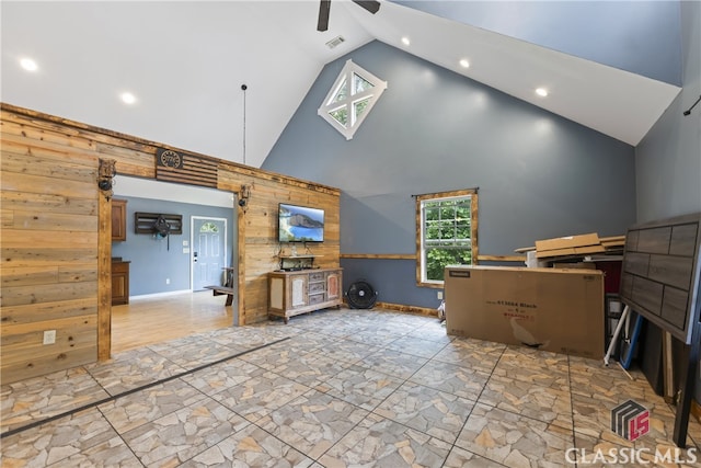 unfurnished living room featuring high vaulted ceiling, ceiling fan, and light tile flooring