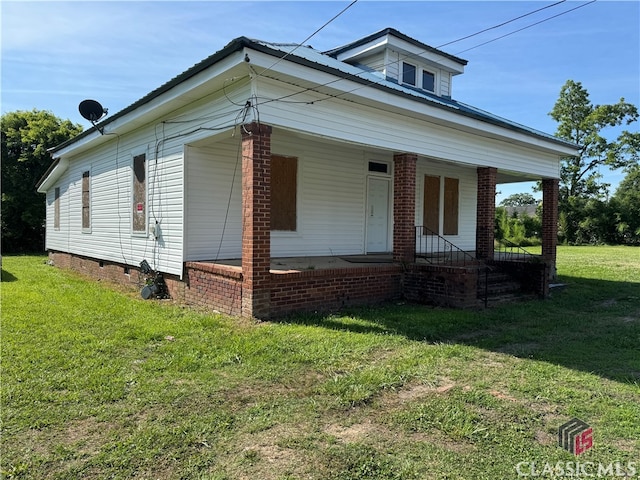 bungalow-style house with a front yard and covered porch