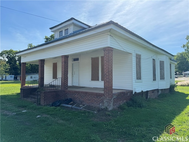 view of front of house with a front yard and covered porch